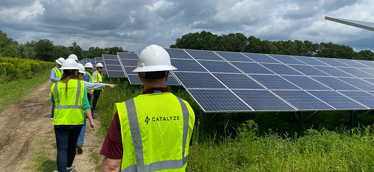 Solar energy experts of Catalyze surveying a solar panel field