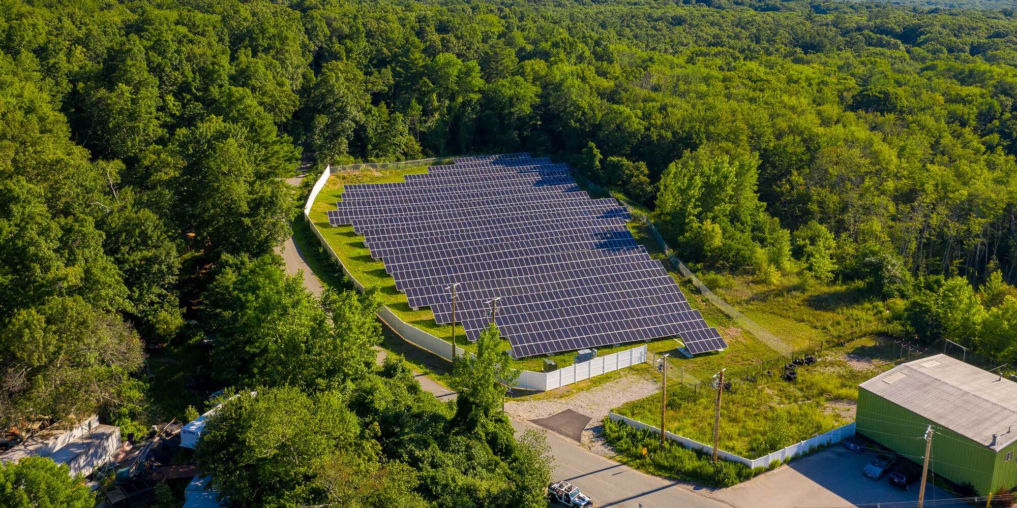 Aerial view of large fenced area full of solar panels
