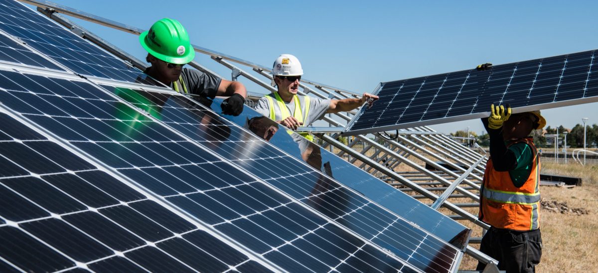 Workers install a solar panel