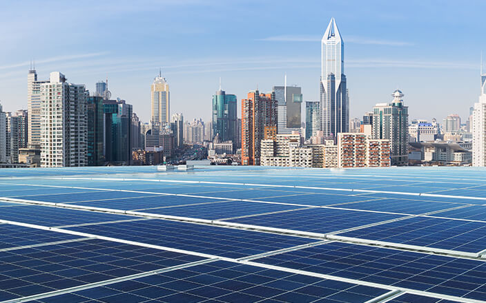 Vast solar panel roof top in a city and reflects the blue sky