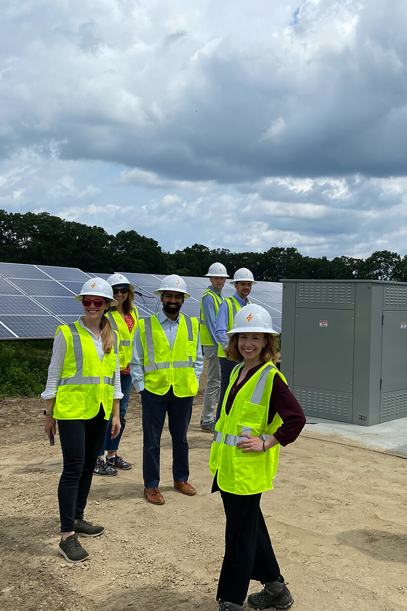 Several Catalyze employees in a solar field wearing safety gear